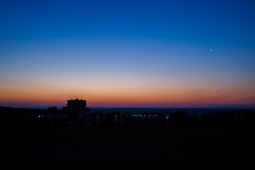 Early dawn in the city with the moon