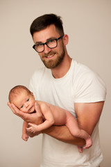 Father holding new born baby on his arm