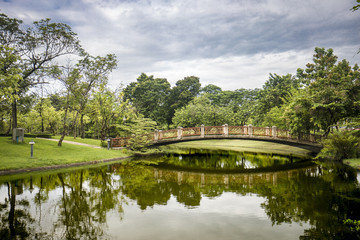 Obraz premium Bridge across the lake in green Garden park nature