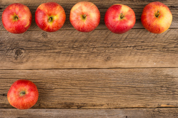 Red apples on the old wooden table.