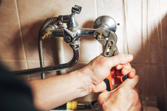 Man Repair And Fixing Leaky Old Faucet In Bathroom