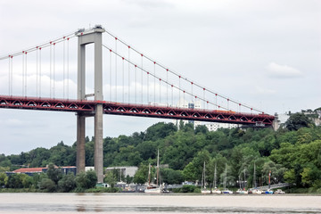 Paysage fluvial, pont suspendu et bateaux à Bordeaux