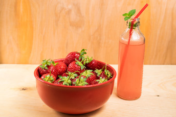 A plate of strawberry. Strawberry lemonade with mint. Light wooden background
