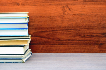 many books stacked close up photo with wood background