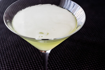 Grasshopper cocktail on black surface.