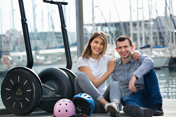 Fototapeta premium Positive tourists couple relaxing near segways