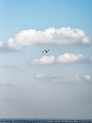 Airplane flying high in sky with white clouds Bologna