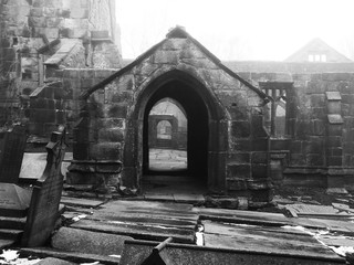 ruined medieval church in heptonstall yorkshire in fog and mist with patches of snow on the ground on the graveyard