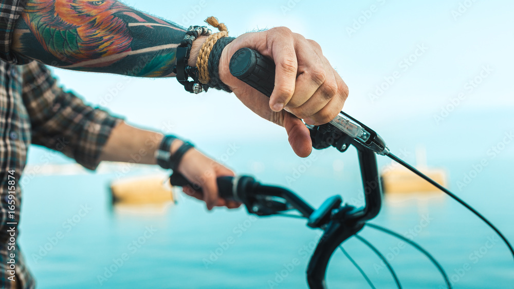 Wall mural closeup of a cyclist hand on bike handlebars, holiday activity transportation concept