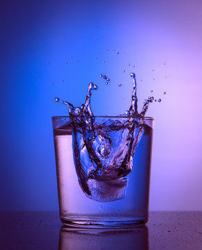 Close up view of the ice splash in water on pink and blue