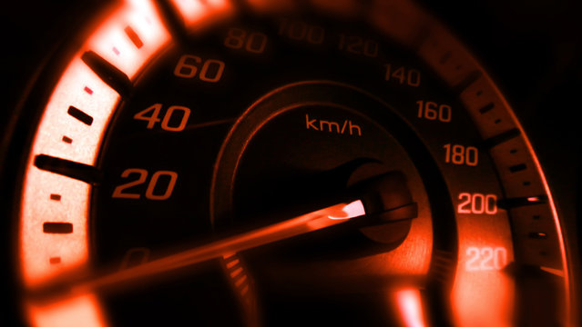 Close up shot of a speed meter in a car with orange light