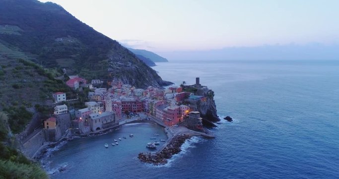 aerial view of travel landmark destination Vernazza,small mediterranean sea town, Cinque terre National Park, Liguria, Italy. Before dawn blue hour night. 4k slow motion 60 fps drone forward video