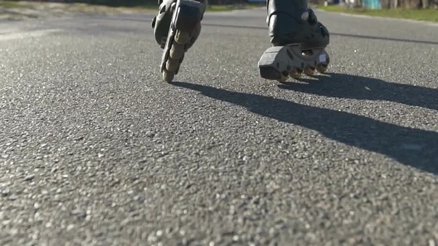 Close-up of a girl at sunset on roller skates. Slow motion