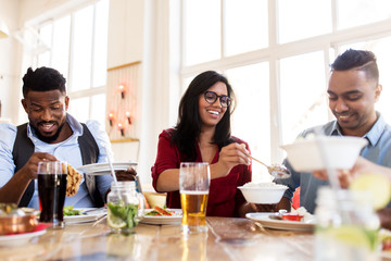 happy friends eating at restaurant