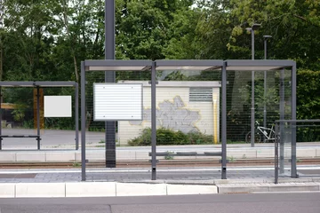 Glasbilder Bahnhof Straßenbahnhaltestelle / Der neue gebaute Glasunterstand einer Straßenbahnhaltestelle an einer Straße.