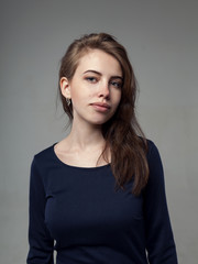 Obraz premium Beautiful woman in a black dress over gray background