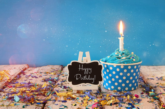 Birthday concept with cupcake and candle on wooden table