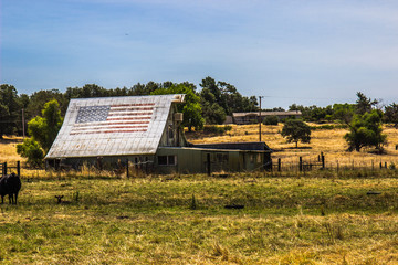 Old Barn & Sheds With American Flag On Roof
