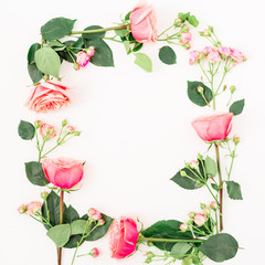 Floral frame of roses and leaves on white background. Flat lay, top view. Pink floral composition