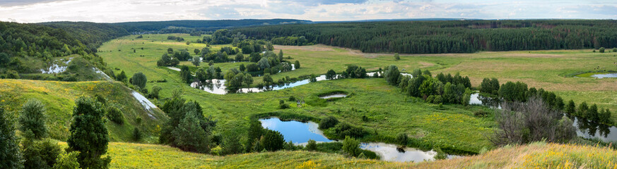 Summertime landscape banner, panorama - river valley of the Siverskyi (Seversky) Donets, the winding river over the meadows between hills and forests, border region of Ukraine near to Russia