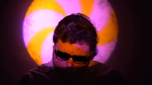 Portrait of a fat man in a multicolored light beam.