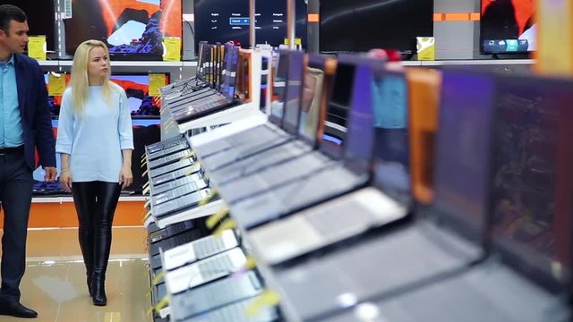 buyers choose a laptop in the store