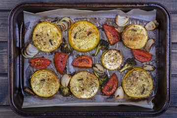 Zucchini, tomatoes, broccoli and onion baked in the oven. Top view