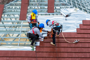 Workers are tiling new roof tiles.