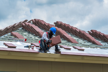 Workers are tiling new roof tiles.