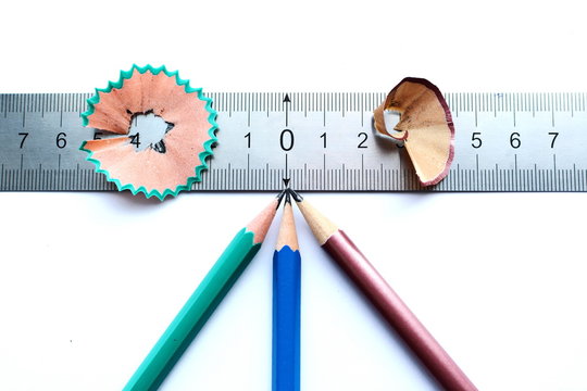 sharp pencil pointing to the zero point on the ruler and sliver on white background isolated
