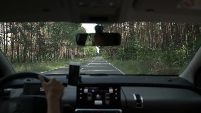 Car driving on two lane road in the forest