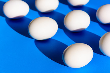 Raw duck eggs white and shiny black on blue paper