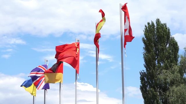 six flags waving on flag poles. China flag and five European Union country flags - Ukraine, Great Britain, Germany, Spain, Switzerland. concept of business cooperation and collaboration