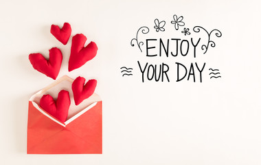 Enjoy Your Day message with red heart cushions coming out of an envelope