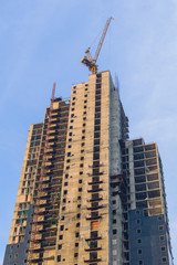 Fototapeta na wymiar Skyscraper Office Tower Under Construction with crane in Pattaya