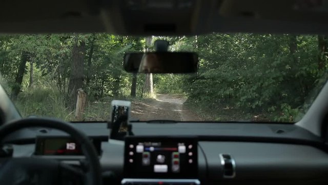 Woman driving car on ground road in the forest