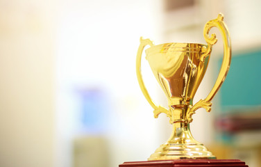 closeup gold trophy with soft-focus and over light in the background