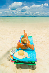 Woman sitting on a bed at the beach