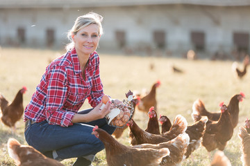 Portrait of female farmer with chicken