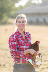 Portrait of female farmer with chicken