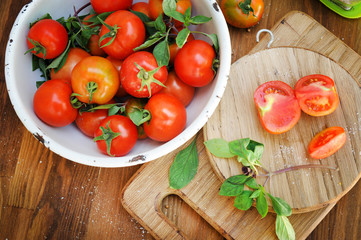 Ripe organic tomatoes in bowl on  board
