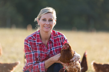 modern female farmer working with chicken