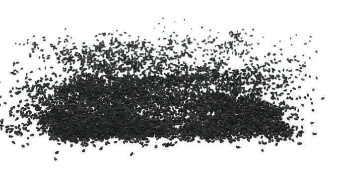 Pile of black cumin seeds isolated on white background