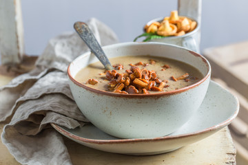 Tasty mushrooms soup on old wooden table
