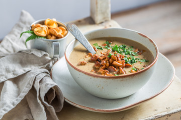 Homemade mushrooms soup on old wooden table