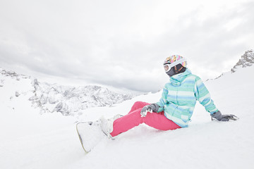 Fototapeta na wymiar Young sitting woman with snowboard