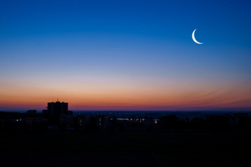 Early dawn in the city with the moon