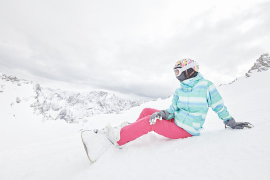 Young sitting woman with snowboard