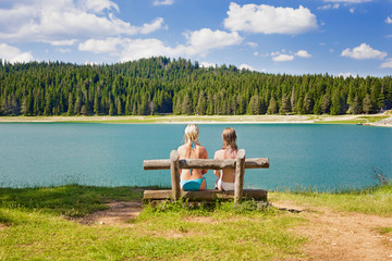 Fototapeta na wymiar 1185789 two girls on a bench near the lake