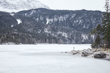 Tourist at winter mountain lake